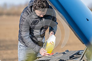 The driver adds yellow wiper fluid to the special tank in the car