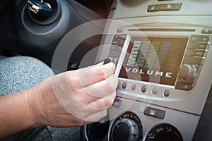 Driver adjusting volume in the car audio system