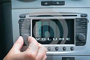 Driver adjusting volume in the car audio system