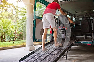 Disabled person on wheelchair using van ramp