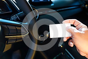 Driver in car hold blank card on right hand