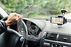 A driver in a car performs tasks necessary to steer the vehicle