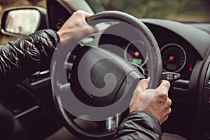 A driver in a car performs tasks necessary to steer the vehicle