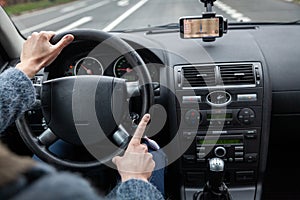 A driver in a car performs tasks necessary to steer the vehicle