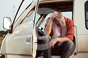 Driver of the car is sitting thinking