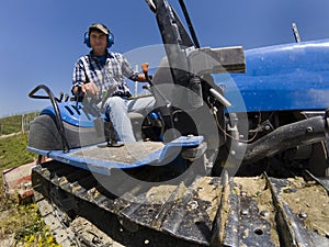Driver on crawler tractor viewed from below
