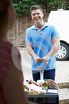 Driver Delivering Online Grocery Order To Female Customer At Home