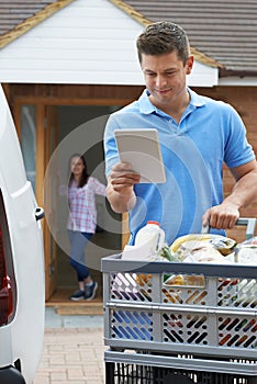 Driver Delivering Online Grocery Order To House Using Digital Ta