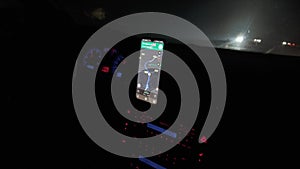 driver drives using navigation in his phone on the car dashboard, night driving on the road