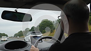 Driver driving car on highway in England using satnav