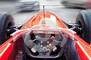 A driver driving a red Formula 1 sports car during a city race at high speed in traffic jams on the street. The spirit of