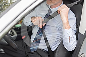 Driver fastening his seat belt