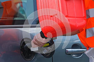 Driver fills the fuel in an empty car tank from canister