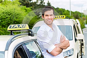 Driver in front of taxi waiting for clients