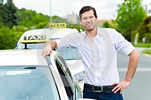 Driver in front of taxi waiting for clients photo