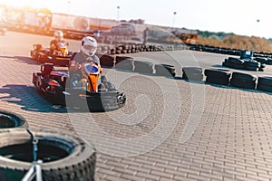 A driver in gear and helmet drives a racing car. In action. Go karts racing, sreet karting, rent. extreme sport. fun entertainment