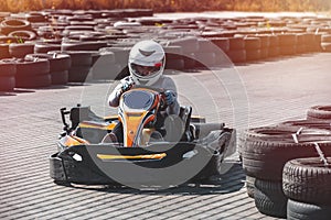 A driver in gear and helmet drives a racing car. In action. Go karts racing, sreet karting, rent. extreme sport. fun entertainment