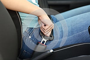 Driver hand fastening seatbelt in a car photo