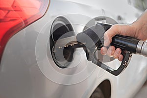 driver hand pumping gasoline car with fuel at the refuel station, higher oil prices photo