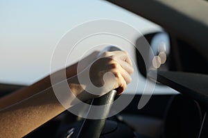 Driver hands holding steering wheel driving a car