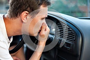 The driver held his nose from the bad smell , air conditioner heating, the concept of faulty air conditioners, bad smell and car,