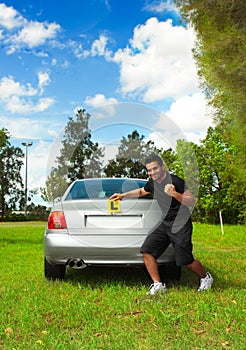 Driver holding learner licence plates beside car