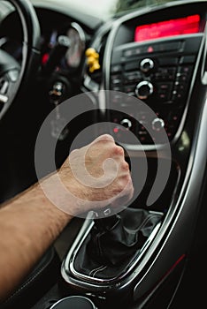 the driver holds his hand on the gear lever