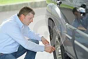 driver inspecting the tire