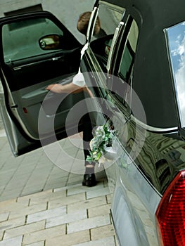 Driver of luxury wedding limousine with bouquet