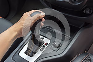 Driver man hand holding automatic transmission in car