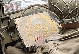 Driver of a military vehicle look at a map of Normandy