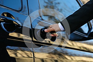 Driver opening door of luxury car, closeup. Chauffeur service