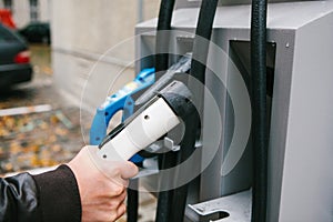 The driver picks up a cable to charge the electric vehicle. A modern and eco-friendly mode of transport that has spread