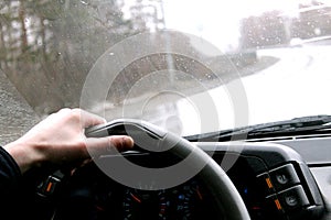 The driver rides behind the wheel of the car in rainy weather