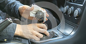 a driver& x27;s hand holding a microfibre and wipe the car interior inside