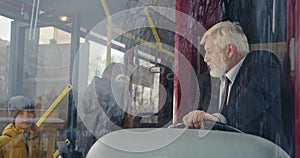 Driver sitting on bus, looking at passengers.