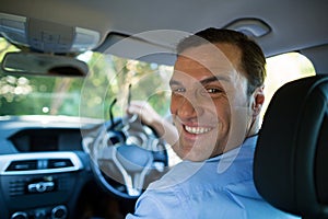 Driver smiling at camera from front seat