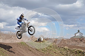 Driver standing on the MX motorcycle is flying over the