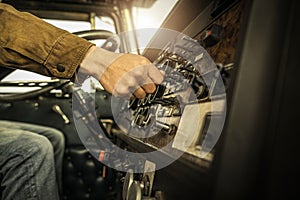 Driver Switching Dashboard Buttons Inside His Classic Semi Truck