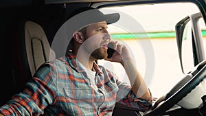 Driver talking by mobile phone while sitting in cabin of his truck