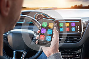 Driver uses a mobile phone with smart driving assistance apps photo