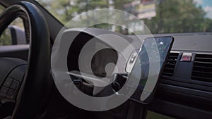 Driver using GPS navigation in mobile phone while driving car. map on the phone in the background of dashboard. Black