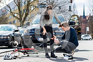 Driver using a sterile bandage to help an injured bicyclist