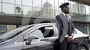 Driver of vip hotel service waiting for passengers near his car, ready to go