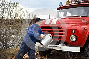 Driver of the water washes the old fire truck