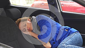 The driver of the woman fell asleep on the driver`s seat on the side of the road. Waiting in the car.