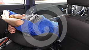 The driver of the woman fell asleep on the driver`s seat on the side of the road. Waiting in the car.