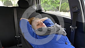 The driver of the woman fell asleep on the driver`s seat on the side of the road. Waiting in the car.