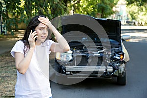 Driver woman in front of wrecked car in car accident. Scared woman in stress holding her head after auto crash calling to auto