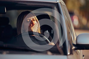 Driver Yawning Behind the Wheel in her Car